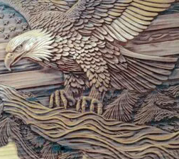 Laser-engraved wood relief carving of a bald eagle in flight